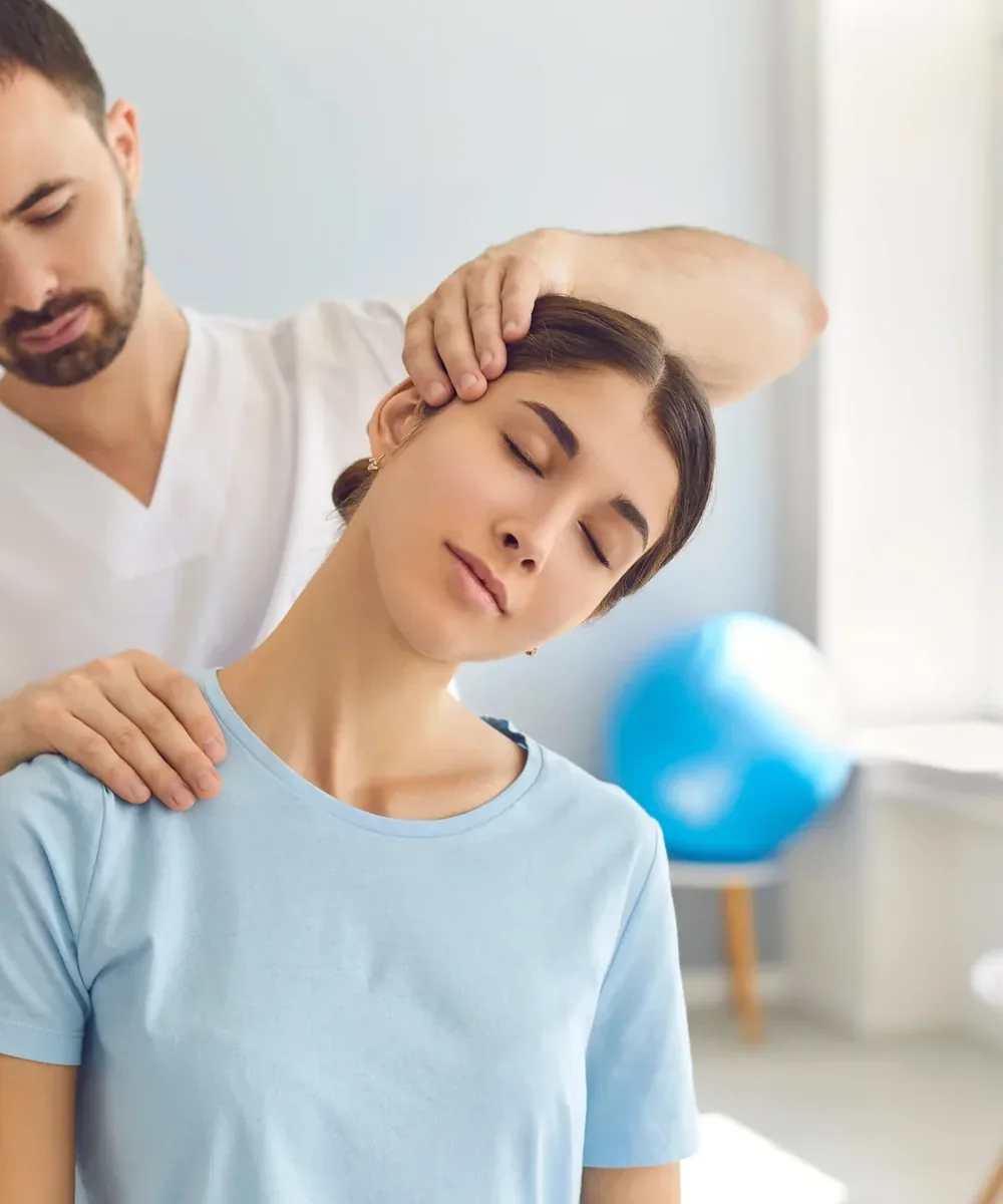A licensed physical therapist testing a seated patient&rsquo;s neck rotation at King Physical Therapy and Fitness in Connellsville, PA