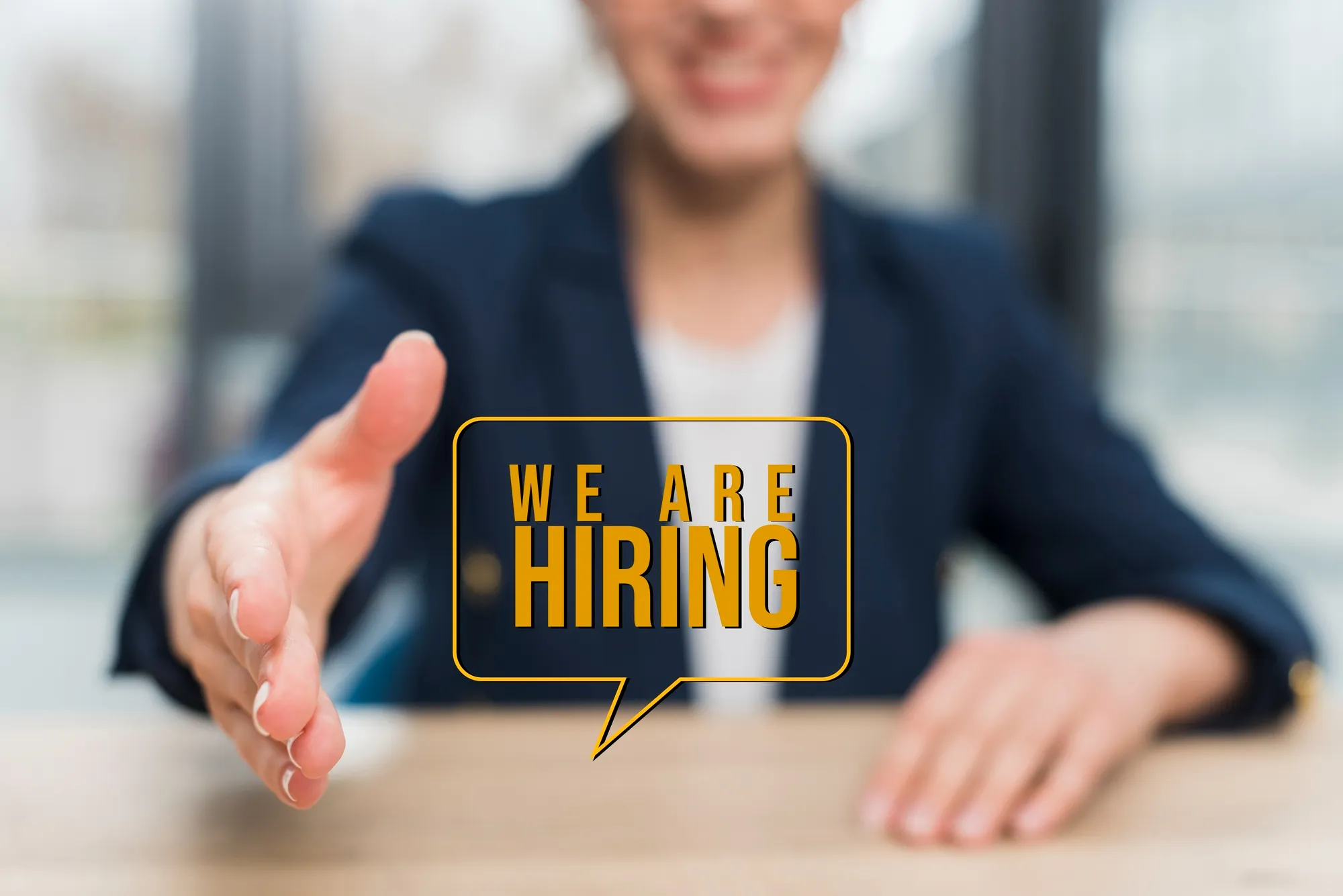 Hiring Person extending hand for handshake with "WE ARE HIRING" text overlay, promoting job opportunities for Patient Care Coordinator at King Physical Therapy and Fitness in Connellsville.